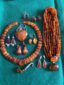 A COLLECTION OF AMBER, RESIN, CARNEILIAN AND OTHER SIMILAR STYLED JEWELLERY MOSTLY SET IN SILVER.