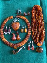 A COLLECTION OF AMBER, RESIN, CARNEILIAN AND OTHER SIMILAR STYLED JEWELLERY MOSTLY SET IN SILVER.