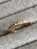 A 9ct HALLMARKED GOLD EIGHT STONE DIAMOND CHANNEL SET HALF ETERNITY RING. FINGER SIZE M. WEIGHT 2.
