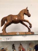 A CARVED WOOD FIGURE OF A CANTERING STALLION