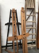 THREE ARTISTS EASELS AND A WOODEN STEP LADDER.