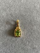 A GREEN GEM SET OVAL CUT PENDENT IN A FOUR CLAW MOUNT. MARKS RUBBED, ASSESSED AS 18ct YELLOW GOLD.