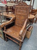 AN ANTIQUE CARVED OAK PANEL BACKED ARM CHAIR