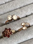 THREE 9ct GOLD DRESS RINGS TO INCLUDE A GARNET CLUSTER, AND TWO BYPASS RINGS. RING SIZES J 1/2, M