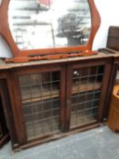 A OAK GLAZED BOOKCASE AND A MIRROR