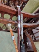 A SWAGGER STICK, A SILVER MOUNTED WALKING STICK AND A EASTERN WHITE METAL UMBRELLA