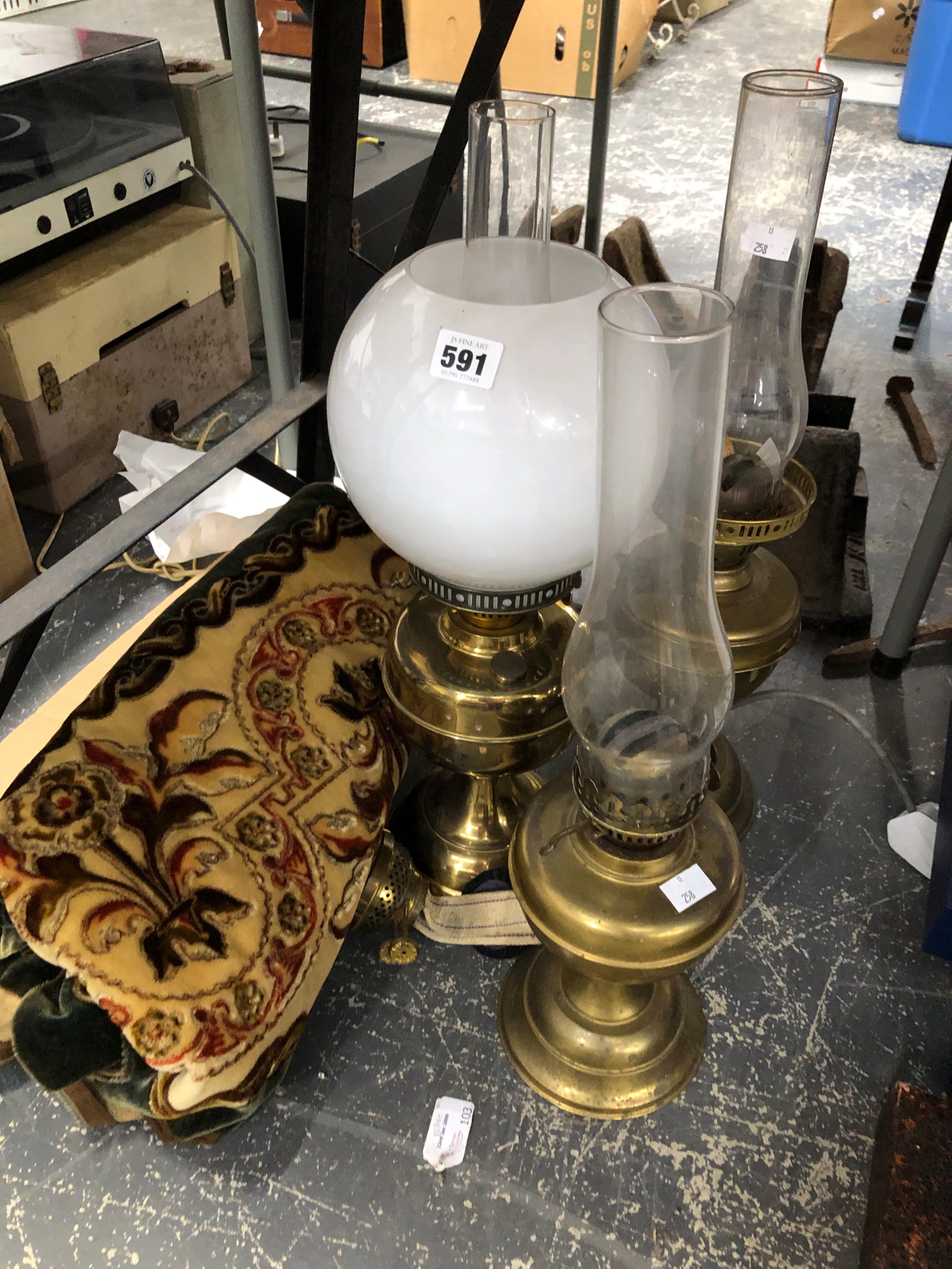 THREE BRASS OIL LAMPS TOGETHER WITH A VELVET DAMASK OANLE