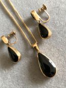 A 9ct HALLMARKED GOLD AND BLACK STONE SET EARRINGS AND PENDANT SET. THE EARRINGS WITH ARTICULATING