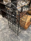 A WROUGHT IRON WINE RACK WITH A ROUND ARCHED DOOR