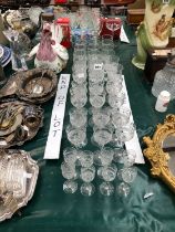 A PART GLASS DRINKING SET CUT WITH SWAGS OF FLOWERS TOGETHER WITH CYLINDRICAL TUMBLERS