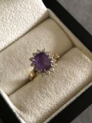 A 9ct GOLD HALLMARKED AMETHYST AND CZ CLUSTER RING. FINGER SIZE N. WEIGHT 2.86grms