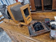 AN ANTIQUE MAGIC LANTERN PROJECTOR ON AN OAK CARRIAGE TOGETHER WITH WITH VARIOUS LENSES TO INCLUDE