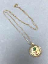 AN ENAMEL AND GOLD SAUDI ARABIA PENDANT SUSPENDED ON A 60cm BOX CHAIN. THE PENDANT AND CHAIN STAMPED