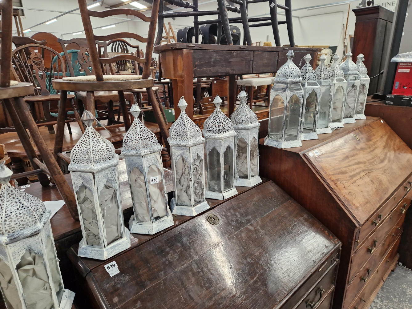 A COLLECTION OF 12 PIERCED METAL AND GLAZED CANDLE LANTERNS.