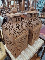 A PAIR OF PIERCED METAL CANDLE LANTERNS.