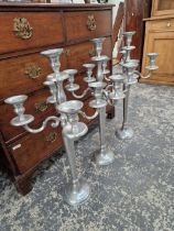 A SET OF THREE TALL ALLOY CANDELABRA.