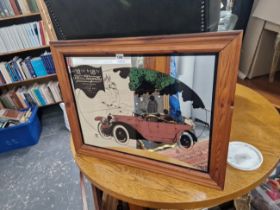 A MIRROR WITH VETERAN CAR IMAGE.