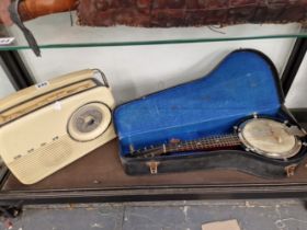 A CASED BANJO TOGETHER WITH A BUSH RADIO