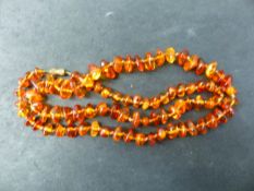 A NECKLACE OF SMALL IRREGULAR GRADUATED AMBER BEADS, FITTED WITH A PLATED SCREW DOWN BARREL CLASP.