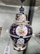 A BLUE GROUND JAR AND COVER DECORATED WITH FLORAL ROUNDELS