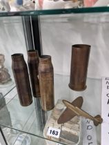 FOUR BRASS SHELL CASES TOGETHER WITH A BRASS MODEL SPITFIRE