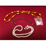 A NECKLACE OF MULTI AMBER BEADS, A MAJORICA COSTUME PEARL NECKLACE, A COALPORT PORCELAIN BROOCH, AND