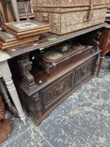 A CARVED OAK MONKS BENCH.