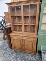 AN ANTIQUE PINE GLAZED BOOKCASE CABINET.