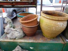 THREE TERRACOTTA PLANT POTS AND TWO COMPOSITE GARDEN ORNAMENTS.