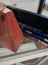 A CASED SLADE FLUTE AND A METRONOME.