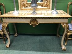 A GILT DETAILED CREAM GROUND CONSOLE TABLE, THE RECTANGULAR TOP OVER A SHELL CENTRED APRON AND