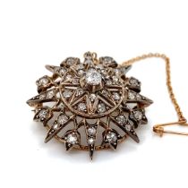 AN ANTIQUE OLD CUT DIAMOND RADIATING STAR BROOCH WITH ATTACHED SAFETY CHAIN. THE PRINCIPLE OLD CUT