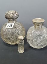 TWO HALLMARKED SILVER CAPPED SPHERICAL CUT GLASS SCENT BOTTLES TOGETHER WITH ANOTHER CYLINDRICAL
