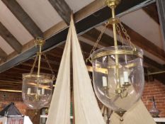 A PAIR OF THREE SOCKET CEILING LIGHTS, EACH SUPPORTED ON BRASS COLUMNS WITHIN INVERTED GLASS DOMES