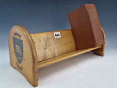 A BLONDE WOOD BOOK TROUGH WITH THE ROUND ARCH ENDS PRINTED WITH THE SHIELD OF HAILEYBURY COLLEGE AND