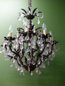 A CHANDELIER ARRANGED WITH EIGHT LIGHTS ABOVE ANOTHER AND HUNG WITH DIAMOND SHAPED DROPS