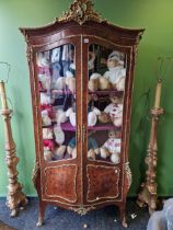 AN ORMOLU MOUNTED KINGWOOD VITRINE WITH ROCOCO CRESTING ABOVE SERPENTINE FRONTED DOORS INLAID WITH