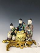 AN EARLY 19th C. ORMOLU MOUNTED EUROPEAN HARD PASTE PORCELAIN GROUP OF THREE CHINESE MEN GATHERED