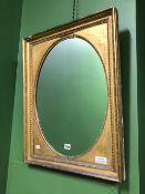 AN OVAL MIRROR IN A GILT RECTANGULAR FRAME WITH BEADED BANDS. 68 x 54cms.