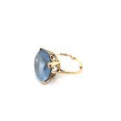 A 9ct HALLMARKED GOLD SYNTHETIC BLUE SPINEL COCKTAIL RING. THE LARGE STONE IN A RAISED FOUR CLAW