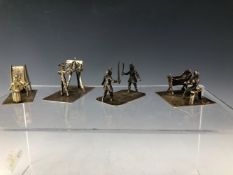FOUR WHITE METAL MINIATURES DEPICTING AN ARTIST, SWORDSMEN, A MOTHER AND BABY AND A LADY BEATING A