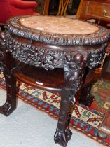 A CHINESE HARDWOOD STAND WITH A WAVY CIRCULAR PINK MARBLE INSET TOP ABOVE A TIER JOINING THE FOUR