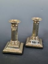 A PAIR OF SILVER FLUTED COLUMN CANDLESTICKS BY THOMAS SCOTT, SHEFFIELD 1907, LOADED. H 13.5cms.