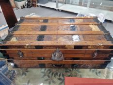 A LEATHER MOUNTED IRON BOUND WOODEN TRUNK WITH FOUR RAISED BARS ON THE RECTANGULAR LID. W 85cms.