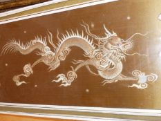 A CHINESE BROWN GROUND SILK WORK PANEL SEWN WITH TWO DRAGONS HEAD TO HEAD WITH A PEARL SHAPE BEARING