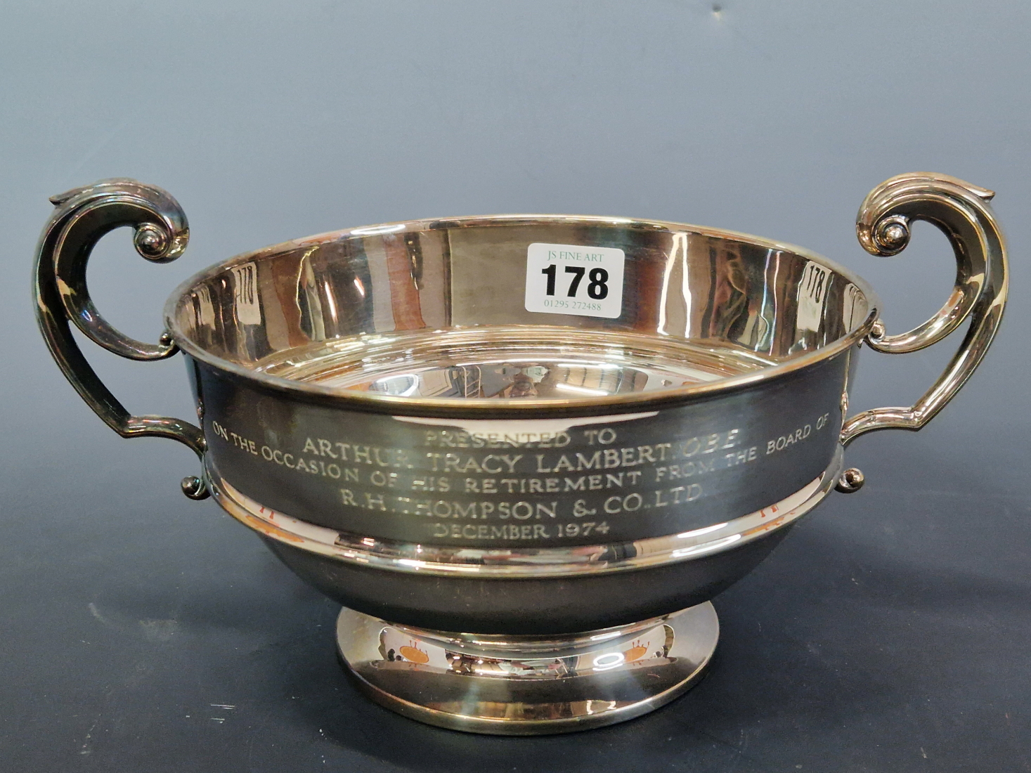 A SILVER TWO HANDLED BOWL BY CARRINGTONS, BIRMINGHAM 1912, INCISED WITH A 1974 PRESENTATION