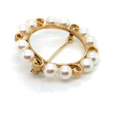 A CULTURED PEARL WREATH BROOCH SET WITH TWELVE 5.5mm PEARLS. DIAMETER 4.5cms. WEIGHT 6.56grms.