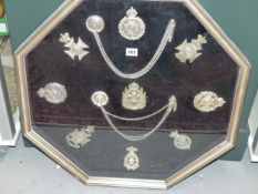 A FRAMED COLLECTION OF MILITARY CROSS BELT BADGES AND CHAINED WHISTLES, TO INCLUDE VICTORIA AND