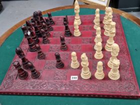 A BROWN AND CREAM COMPOSITION CHESS SET ON A RED BOARD, THE KINGS. H 16cms.