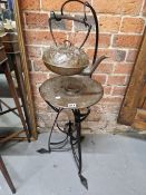 AN ARTS AND CRAFTS COPPER KETTLE AND BURNER ON AN ART NOUVEAU WROUGHT IRON TRIPOD STAND, THE